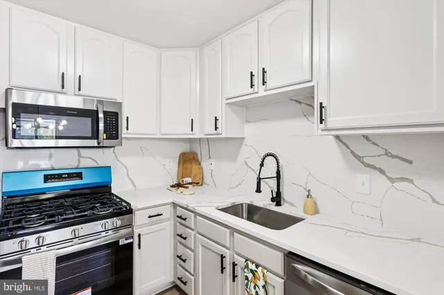 a kitchen with granite countertop a sink stove and cabinets
