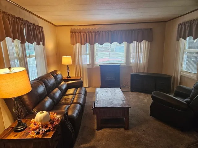 a living room with furniture fireplace and a large window