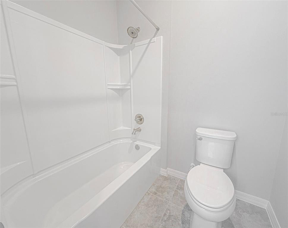 7641 Southwest 63rd Ln Road Ocala, FL 34474 - Photo 6 of 29 a white toilet sitting next to a bath tub