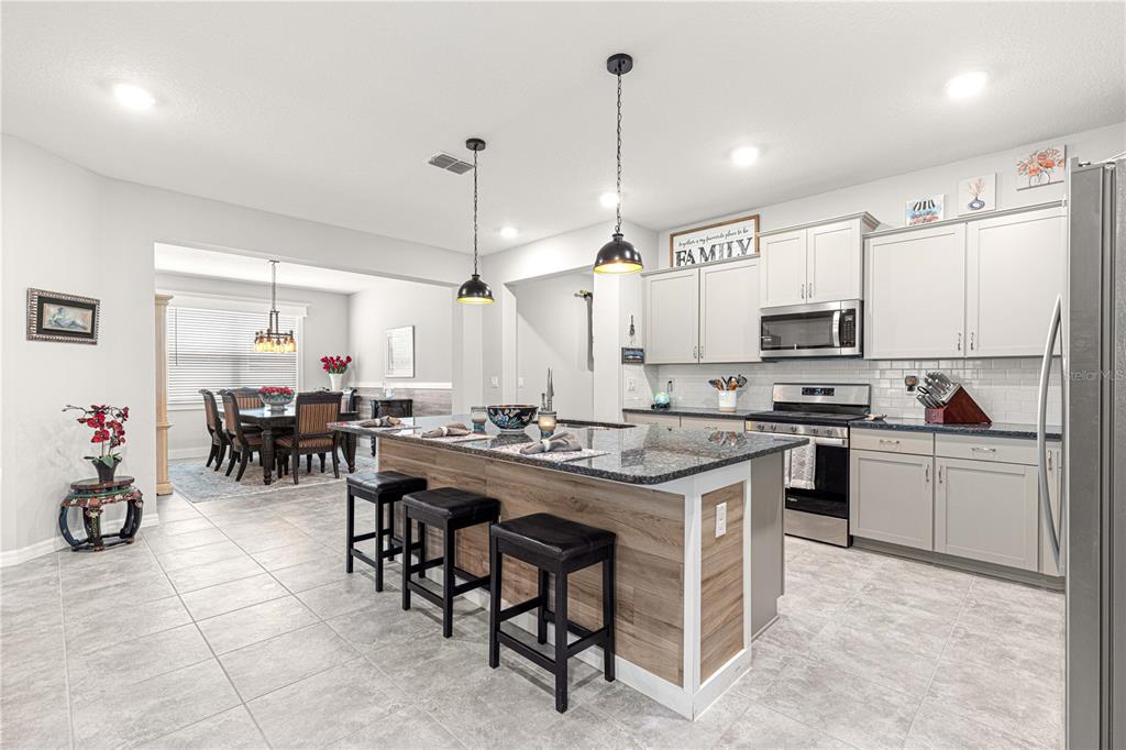 7641 Southwest 63rd Ln Road Ocala, FL 34474 - Photo 9 of 29 a kitchen with appliances a sink a counter and chairs
