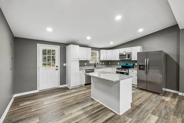 a kitchen with refrigerator and cabinets