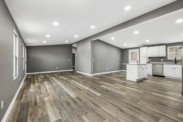 a view of a kitchen with kitchen island wooden floor center island and stainless steel appliances