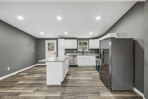 a kitchen with white cabinets and stainless steel appliances