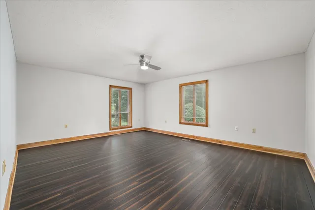 an empty room with a ceiling fan and a window
