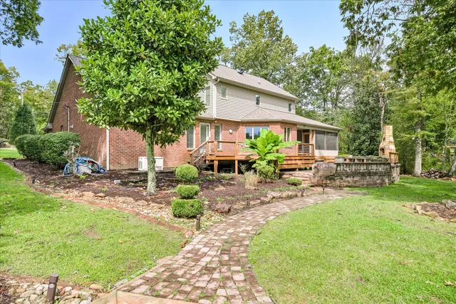 a view of a house with a yard and large tree
