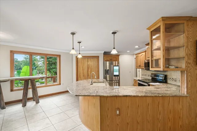 a kitchen with stainless steel appliances granite countertop a sink a counter space and cabinets