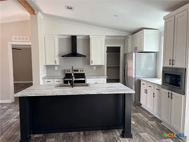 a kitchen with stainless steel appliances kitchen island granite countertop a sink stove and refrigerator