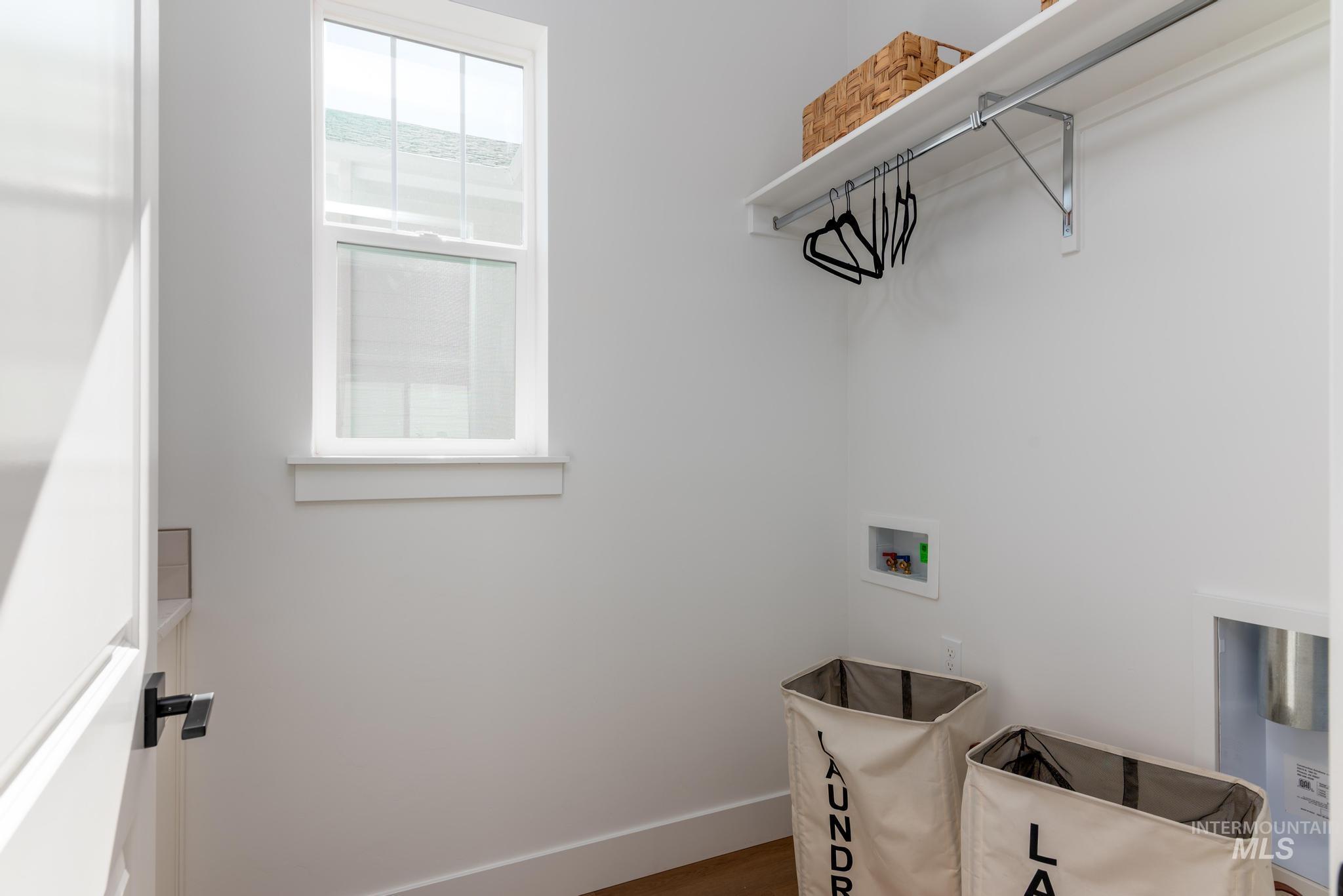 14703 Serenity Pt Street Caldwell, ID 83607 - Photo 23 of 45 Dedicated laundry area featuring a white framed window, integrated shelving, and a hanging rod