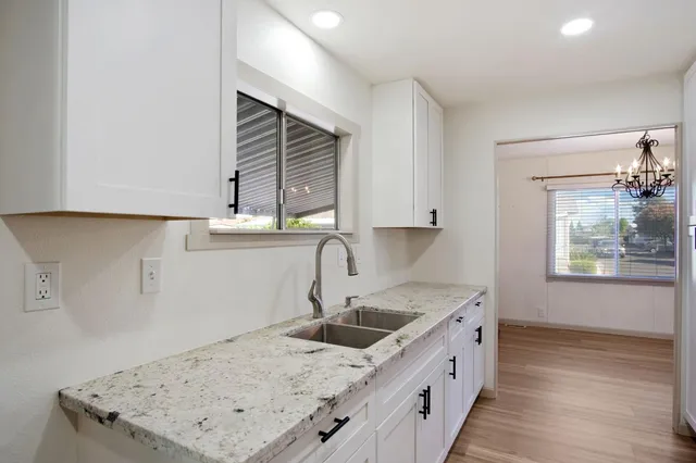 a kitchen with a sink a stove and cabinets