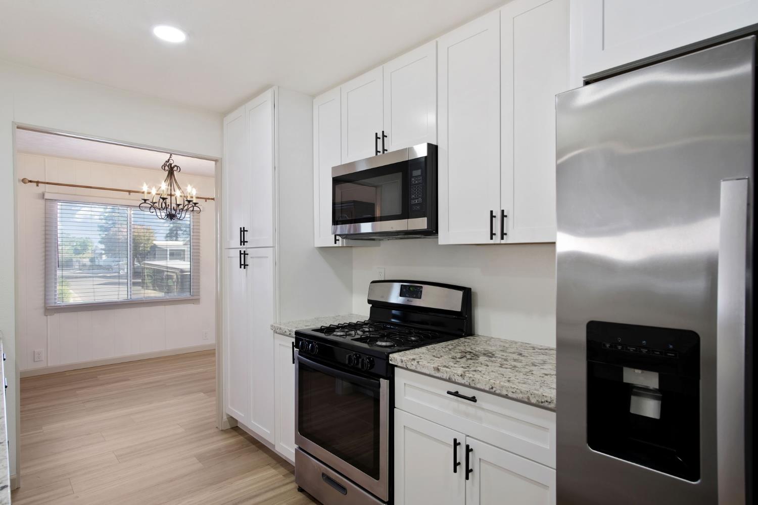 2621 Prescott Road, Unit 224 224 Modesto, CA 95350 - Photo 13 of 23 a kitchen with stainless steel appliances granite countertop a stove a microwave and a refrigerator