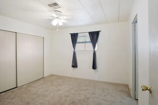 an empty room with chandelier fan
