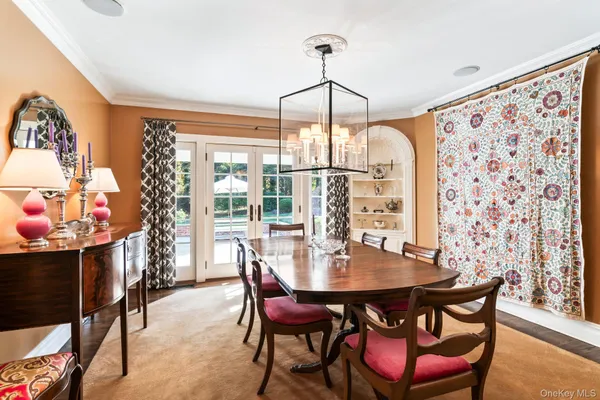 a dining room with furniture a chandelier and wooden floor