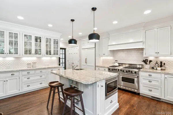 a kitchen with a stove a sink and wooden floors