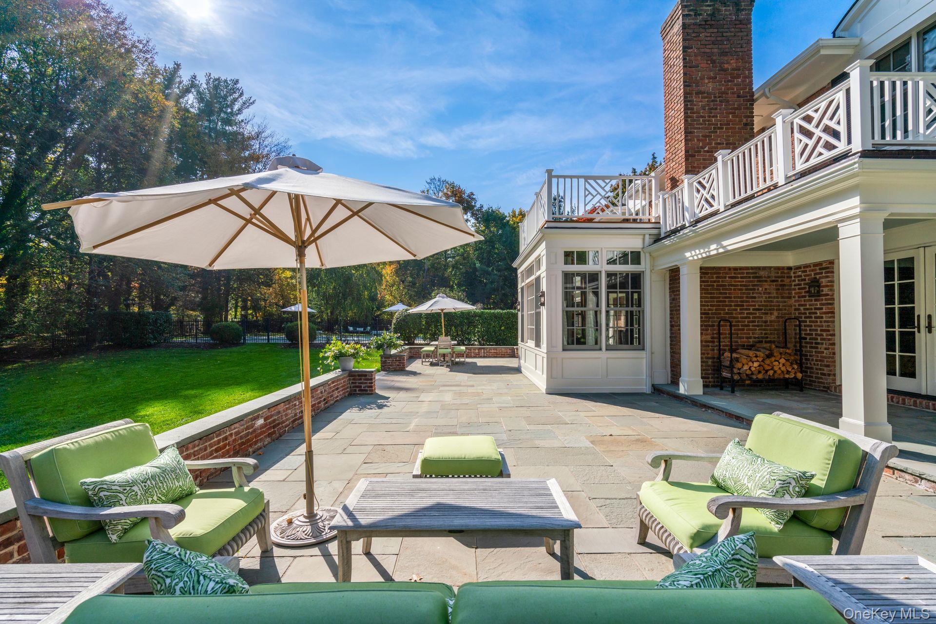 30 Underhill Road Locust Valley, NY 11560 - Photo 28 of 32 a view of a patio with couches table and chairs under an umbrella