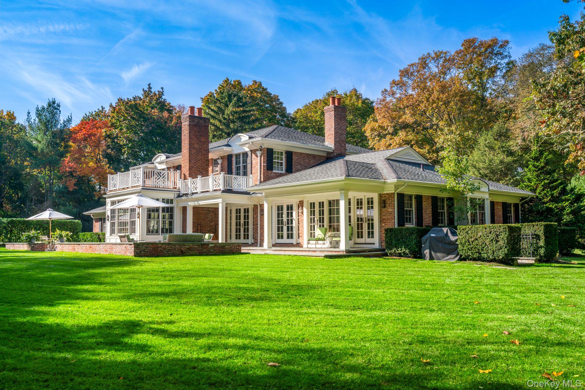 30 Underhill Road Locust Valley, NY 11560 - Photo 30 of 32 a front view of a house with a yard table and chairs