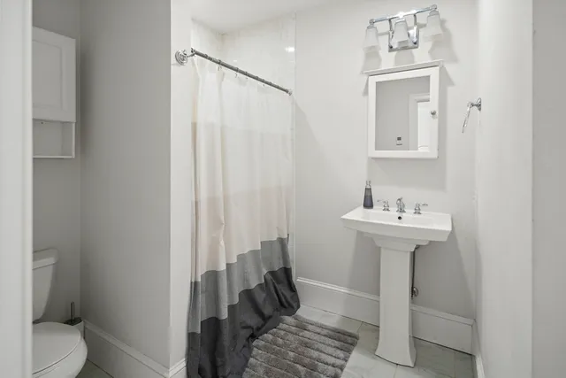 a bathroom with a sink toilet and shower