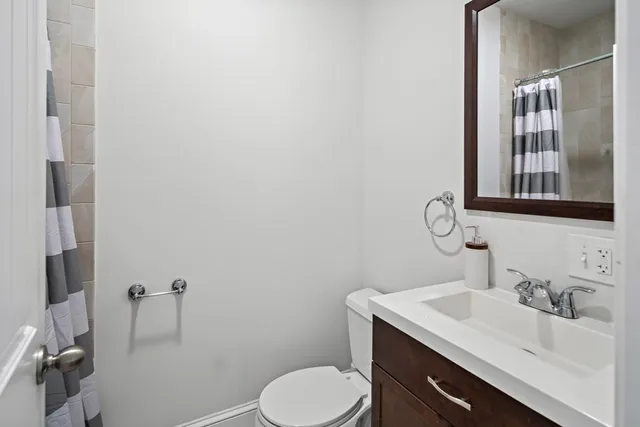 a bathroom with a sink toilet and mirror
