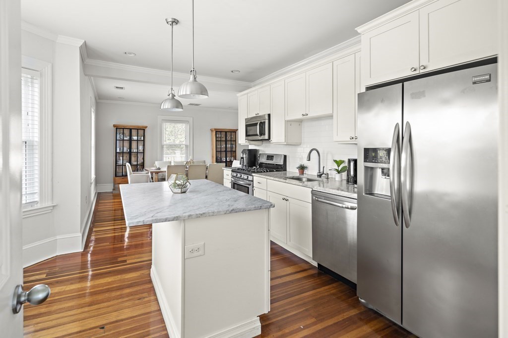 1281 Walnut Street, Unit 2 Newton, MA 02461 - Photo 18 of 30 a kitchen with stainless steel appliances granite countertop a refrigerator a sink dishwasher a stove and white cabinets with wooden floor