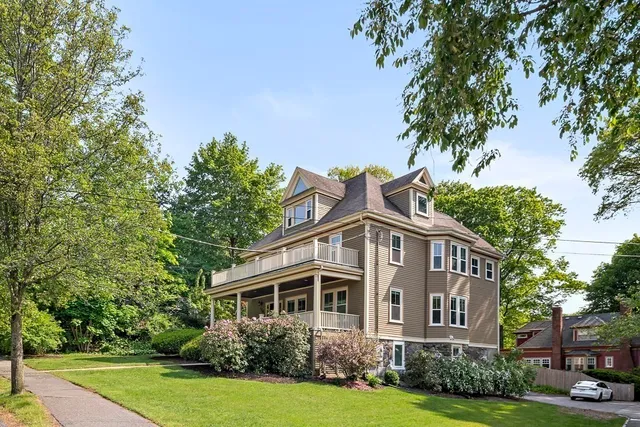a front view of a house with a yard and trees