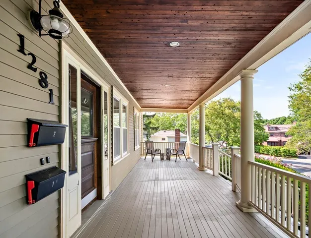 a balcony with wooden floor and outdoor seating
