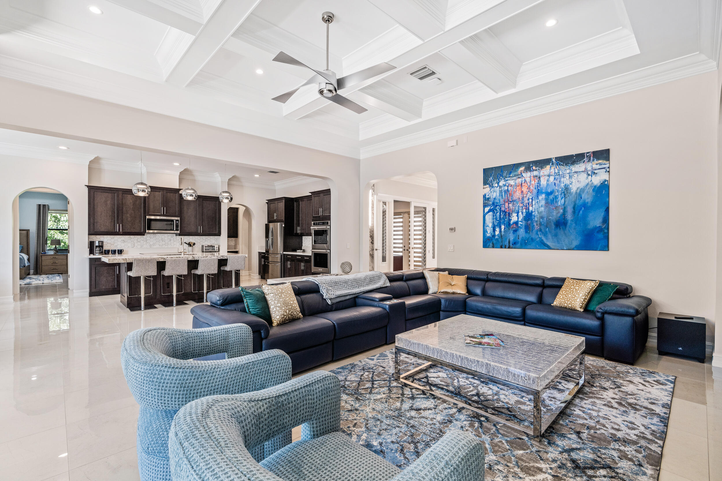 19240 Southeast Hidden Bridge Court Jupiter, FL 33458 - Photo 11 of 42 a living room with furniture kitchen view and a chandelier