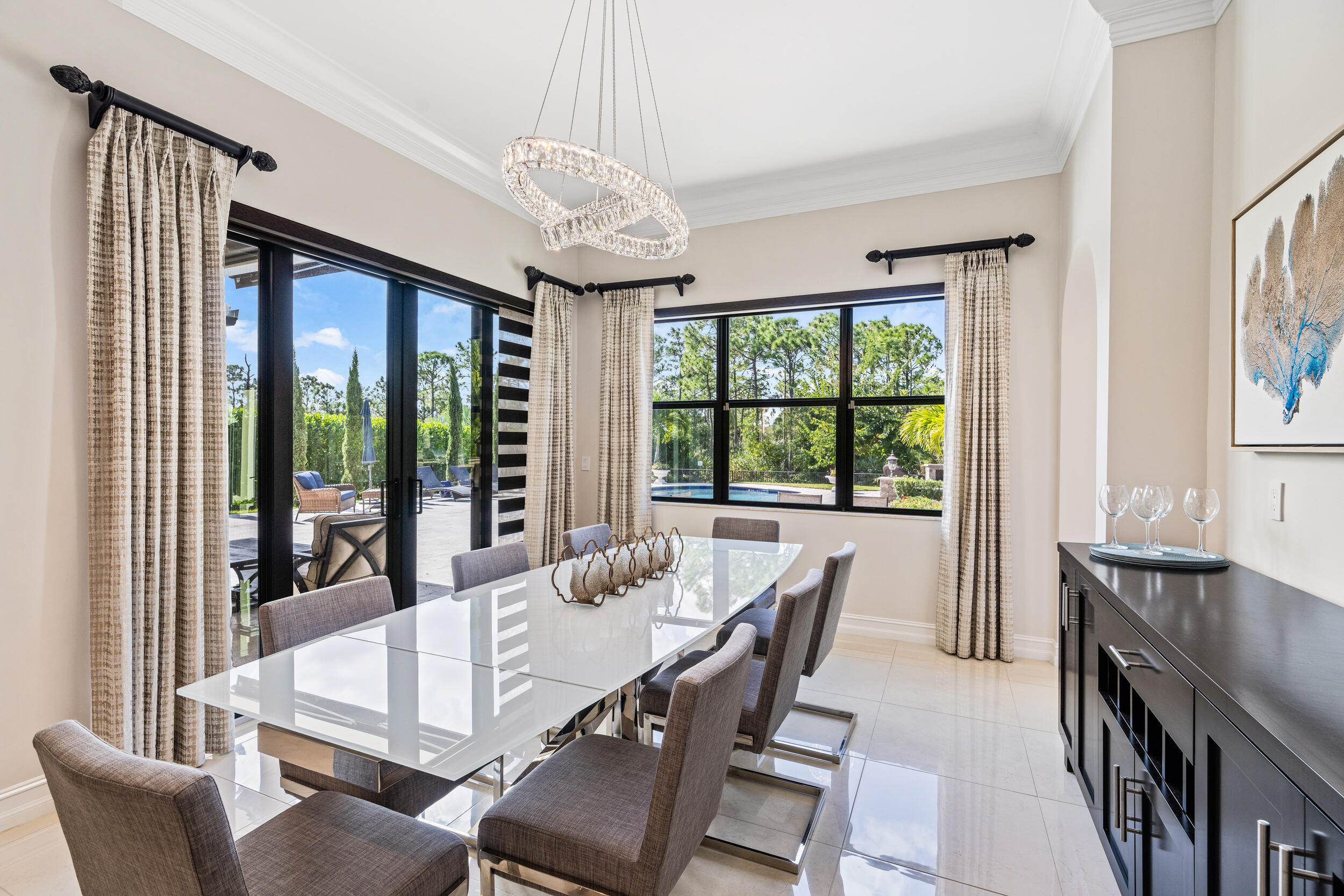 19240 Southeast Hidden Bridge Court Jupiter, FL 33458 - Photo 16 of 42 a view of a dining room with furniture large windows and wooden floor