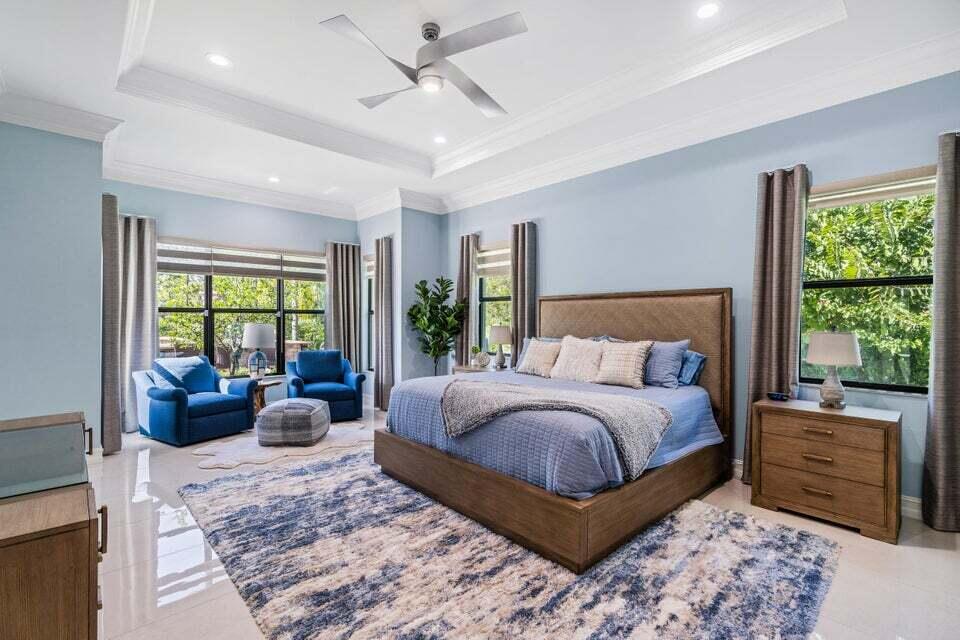 19240 Southeast Hidden Bridge Court Jupiter, FL 33458 - Photo 20 of 42 a bedroom with a large bed and windows