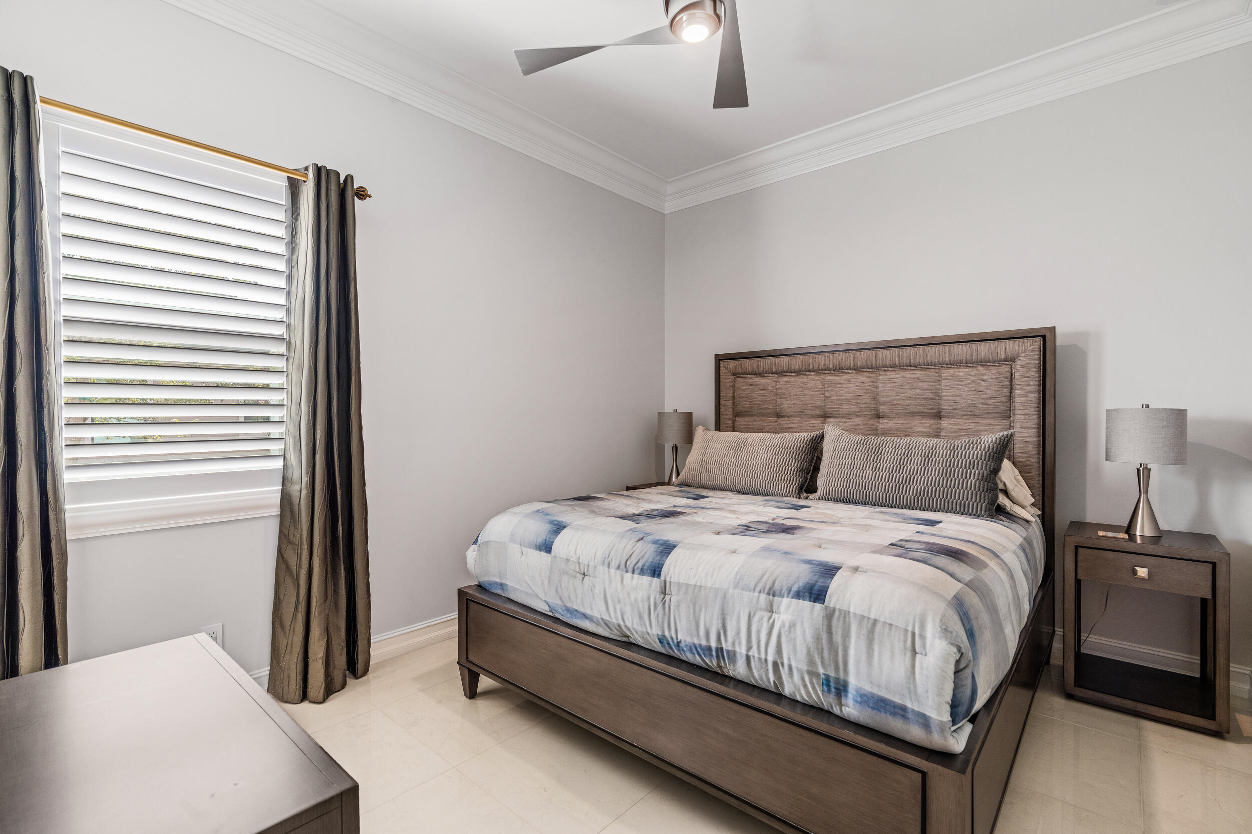 19240 Southeast Hidden Bridge Court Jupiter, FL 33458 - Photo 25 of 42 a bed sitting in a bedroom next to a window and a chandelier