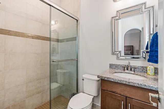 a bathroom with a granite countertop sink toilet and shower