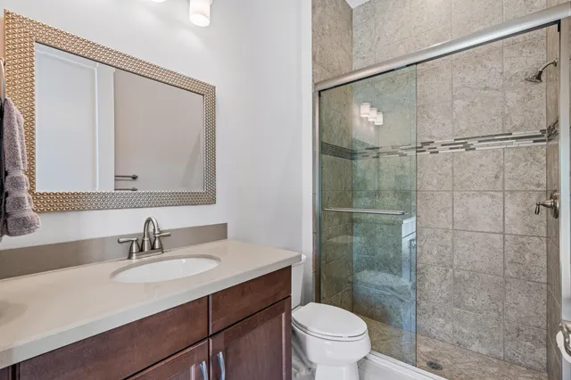 a bathroom with a granite countertop sink toilet and shower