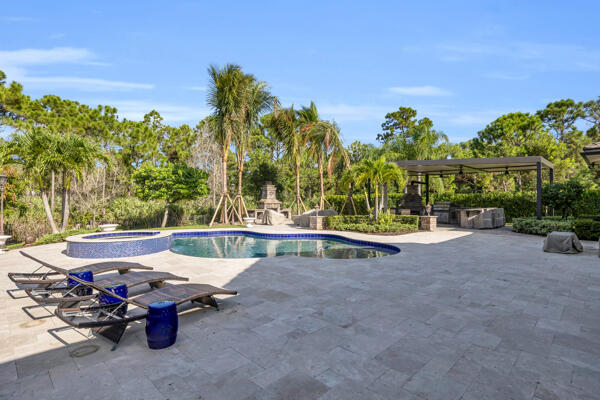 19240 Southeast Hidden Bridge Court Jupiter, FL 33458 - Photo 36 of 42 a view of a patio with a table and chairs under an umbrella