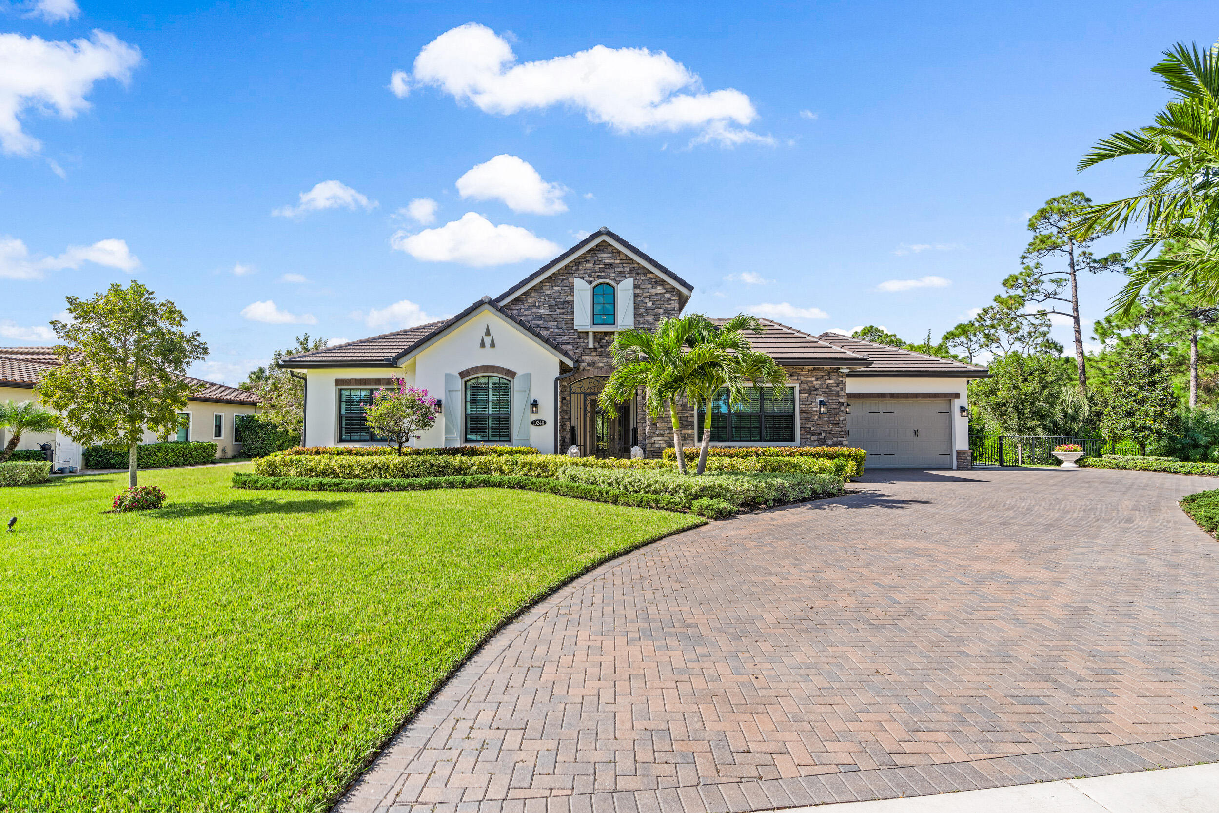 19240 Southeast Hidden Bridge Court Jupiter, FL 33458 - Photo 4 of 42 a front view of a house with garden