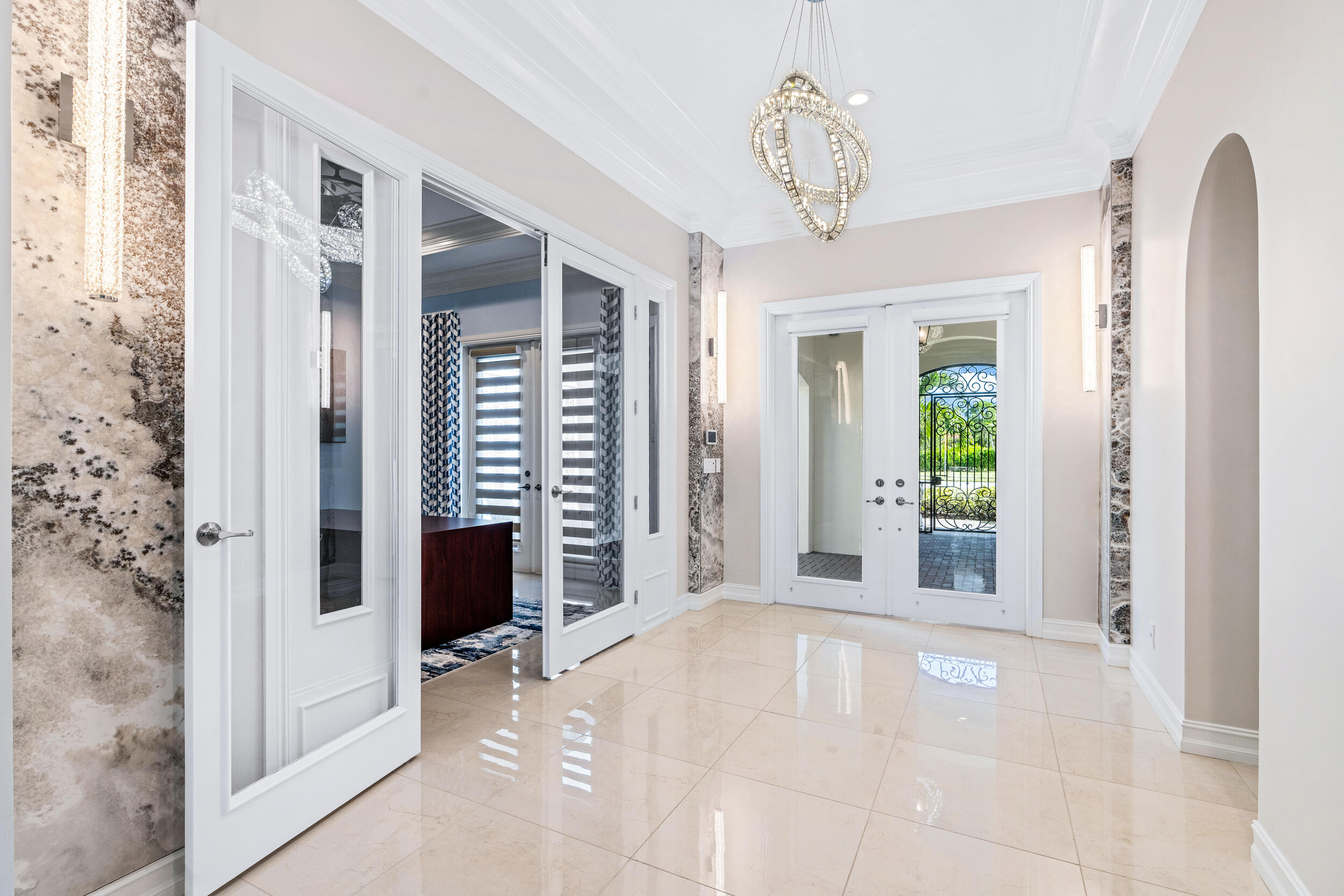 19240 Southeast Hidden Bridge Court Jupiter, FL 33458 - Photo 7 of 42 a view of a hallway with windows and chandelier