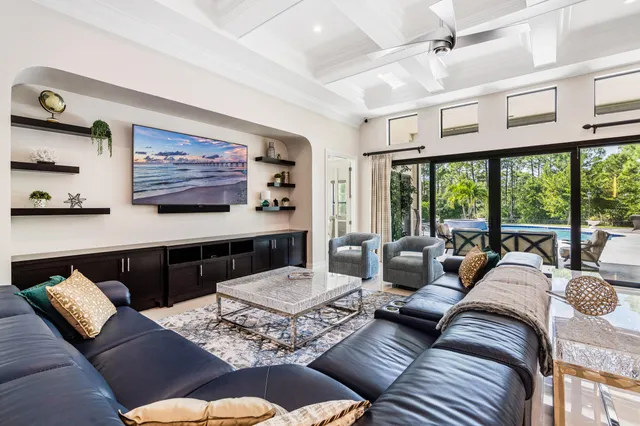 a living room with furniture kitchen view and large windows