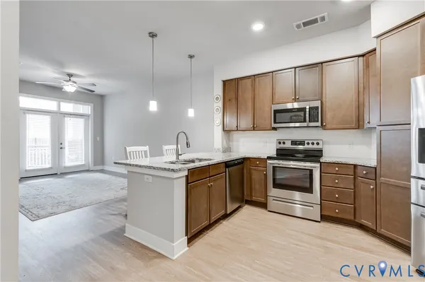 a kitchen with stainless steel appliances granite countertop a refrigerator stove and microwave