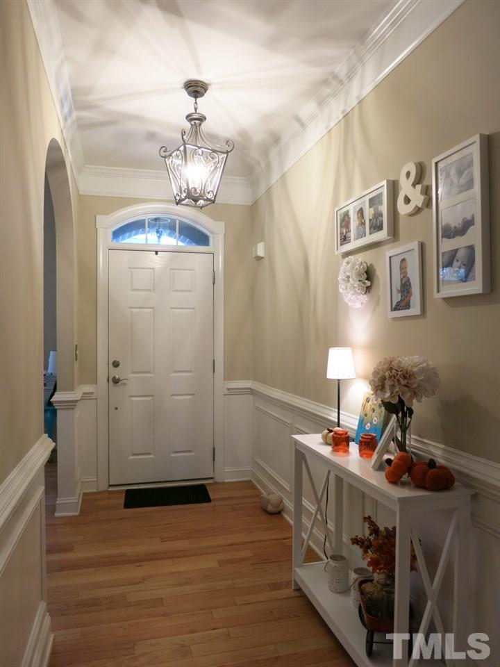 3205 Canes Way Raleigh, NC 27614 - Photo 24 of 25 The welcoming Foyer w/panel wainscot, chair rail molding & coat closet. Home features a spacious, open floor plan, hardwood flrs, plantation shutters, deep crown molding, window transoms & 9’ smooth ceilings throughout.