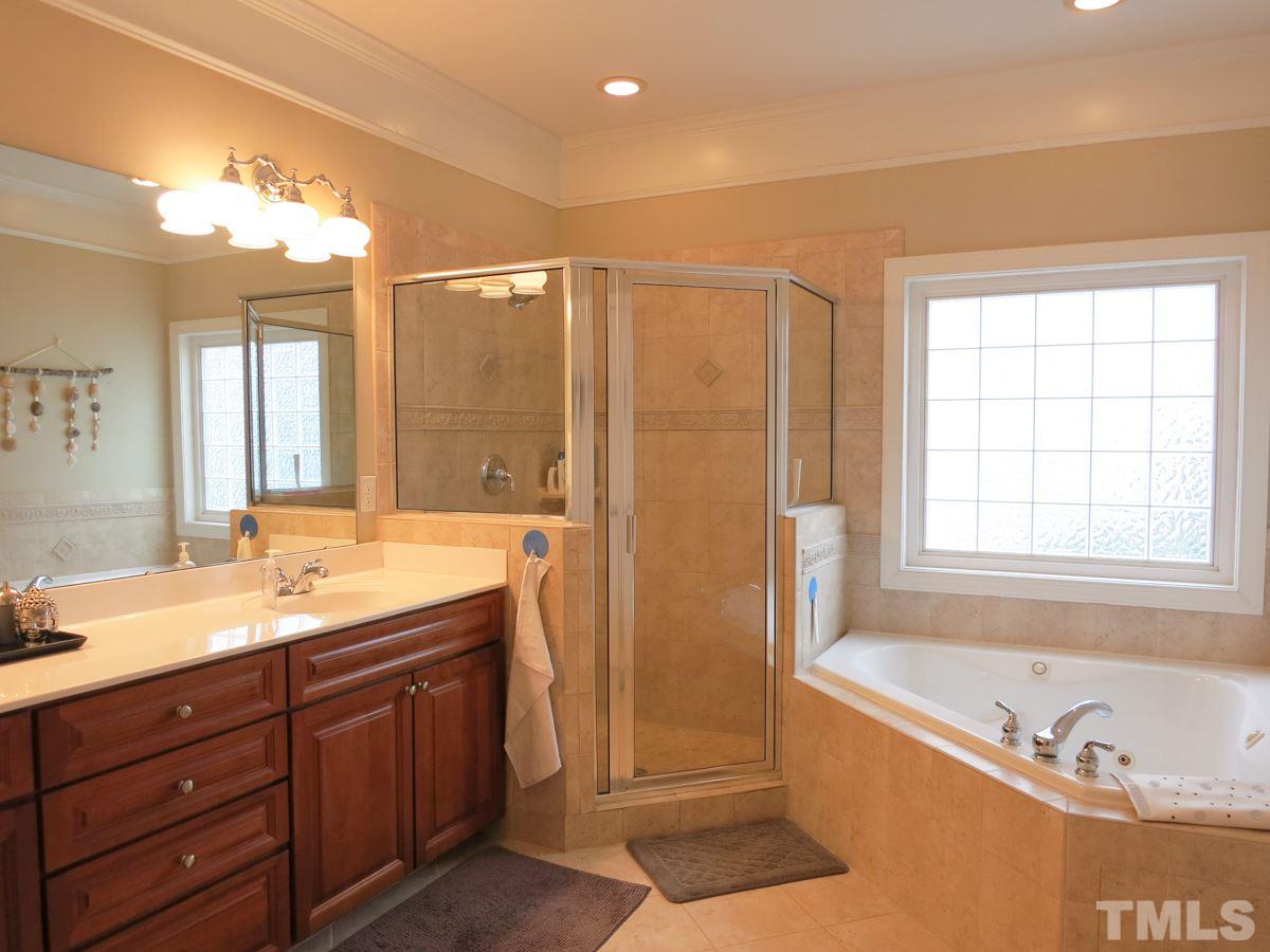 3205 Canes Way Raleigh, NC 27614 - Photo 13 of 25 Spa-like Master Bath features a corner jetted tub, lg tiled shower, long vanity w/double sinks, tile floor & private toilet rm.