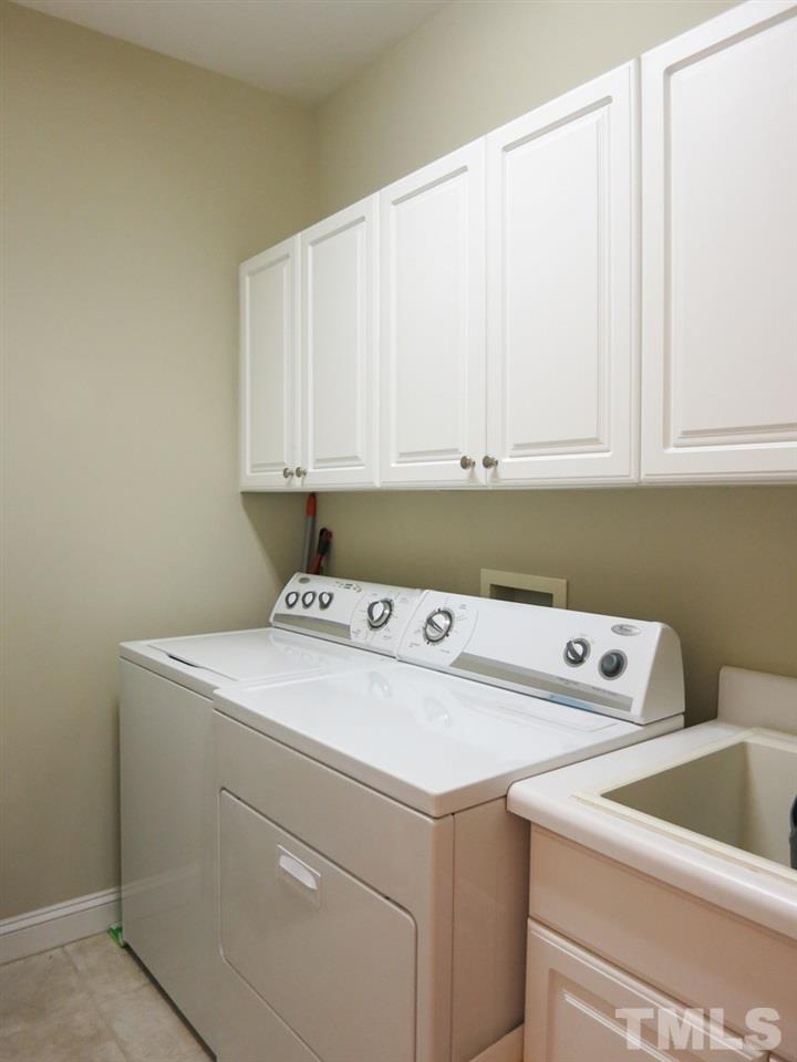 3205 Canes Way Raleigh, NC 27614 - Photo 14 of 25 The tiled main flr Laundry/Mud Rm w/deep sink & wall cabinets accesses the Garage.