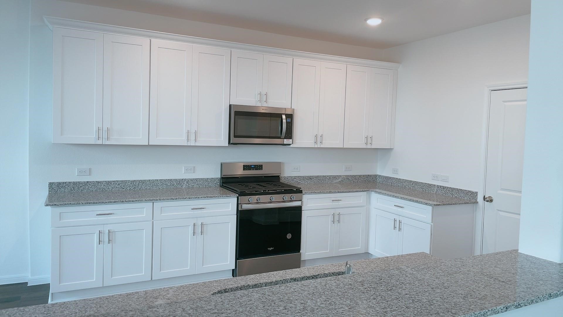 10212 Gates Mill Road Houston, TX 77034 - Photo 10 of 17 a kitchen with white cabinets and a stove with dishwasher