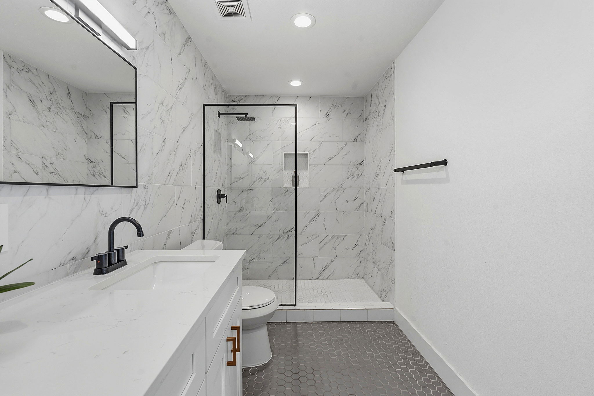 4403 Elmsgrove Drive Austin, TX 78721 - Photo 35 of 38 A well-appointed bathroom features a glass-enclosed shower and contemporary vanity with a black faucet.