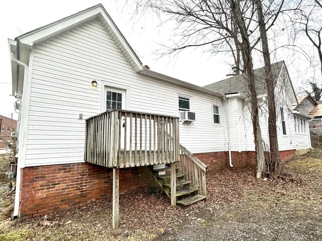 a view of a house with a wooden deck and a backyard
