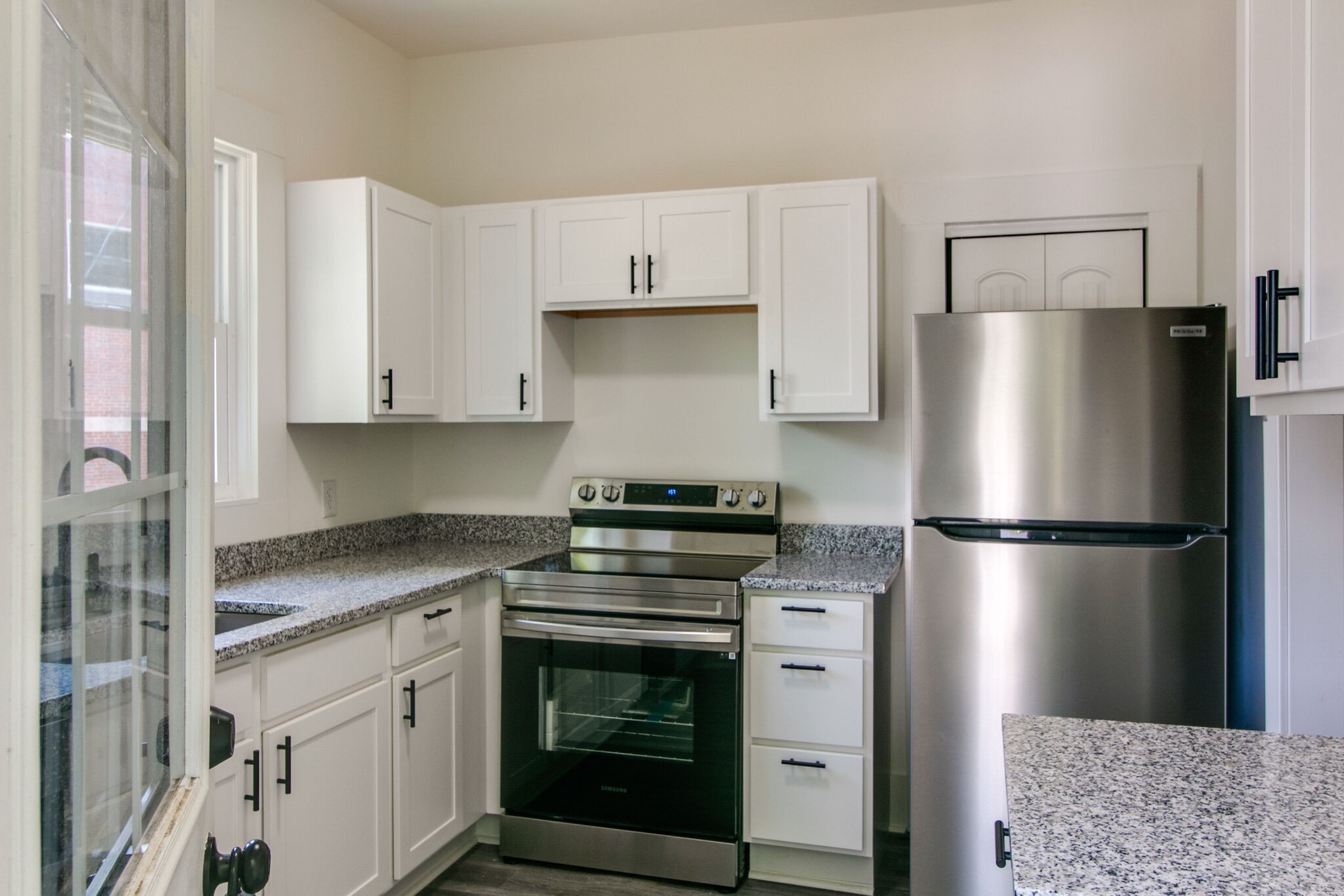 143 Emory Street, Unit C Clarksville, TN 37040 - Photo 3 of 13 a kitchen with stainless steel appliances granite countertop a refrigerator a stove a sink and white cabinets
