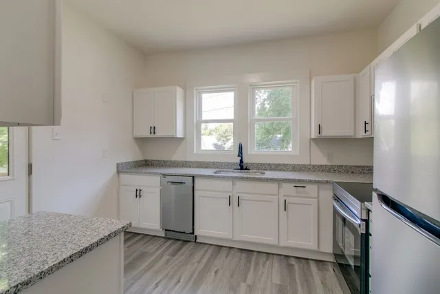a kitchen with sink cabinets and wooden floor