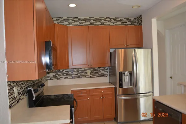 a kitchen with stainless steel appliances granite countertop a refrigerator and a stove