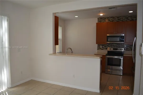 a kitchen with stainless steel appliances a sink a stove a microwave a refrigerator and cabinets