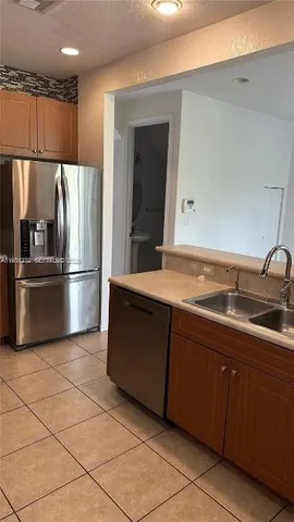 a kitchen with stainless steel appliances granite countertop a refrigerator and a sink