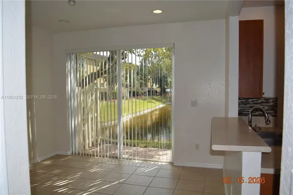 a view of a livingroom with a floor to ceiling window and wooden floor