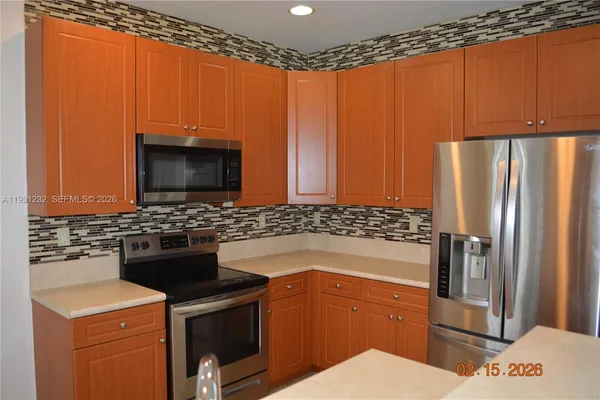 a kitchen with stainless steel appliances a refrigerator and a stove top oven