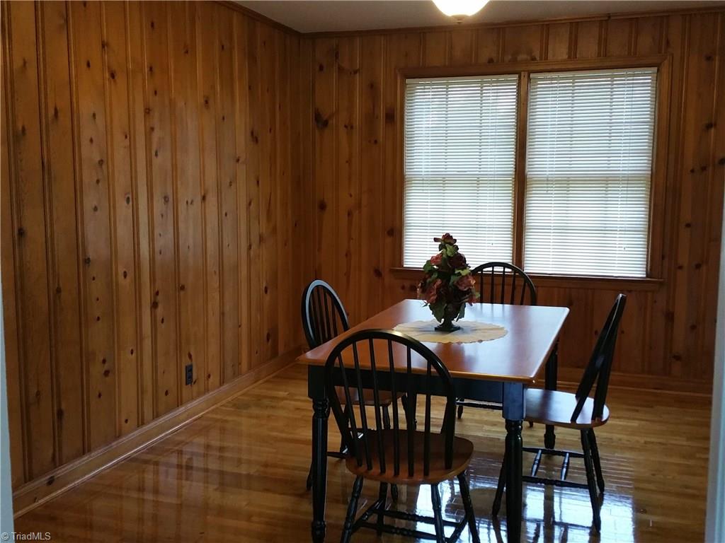Glistening wood floors in dining room with knotty pine paneling.  
