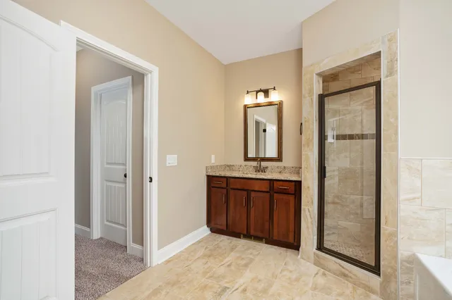 a bathroom with a granite countertop sink a mirror and a shower